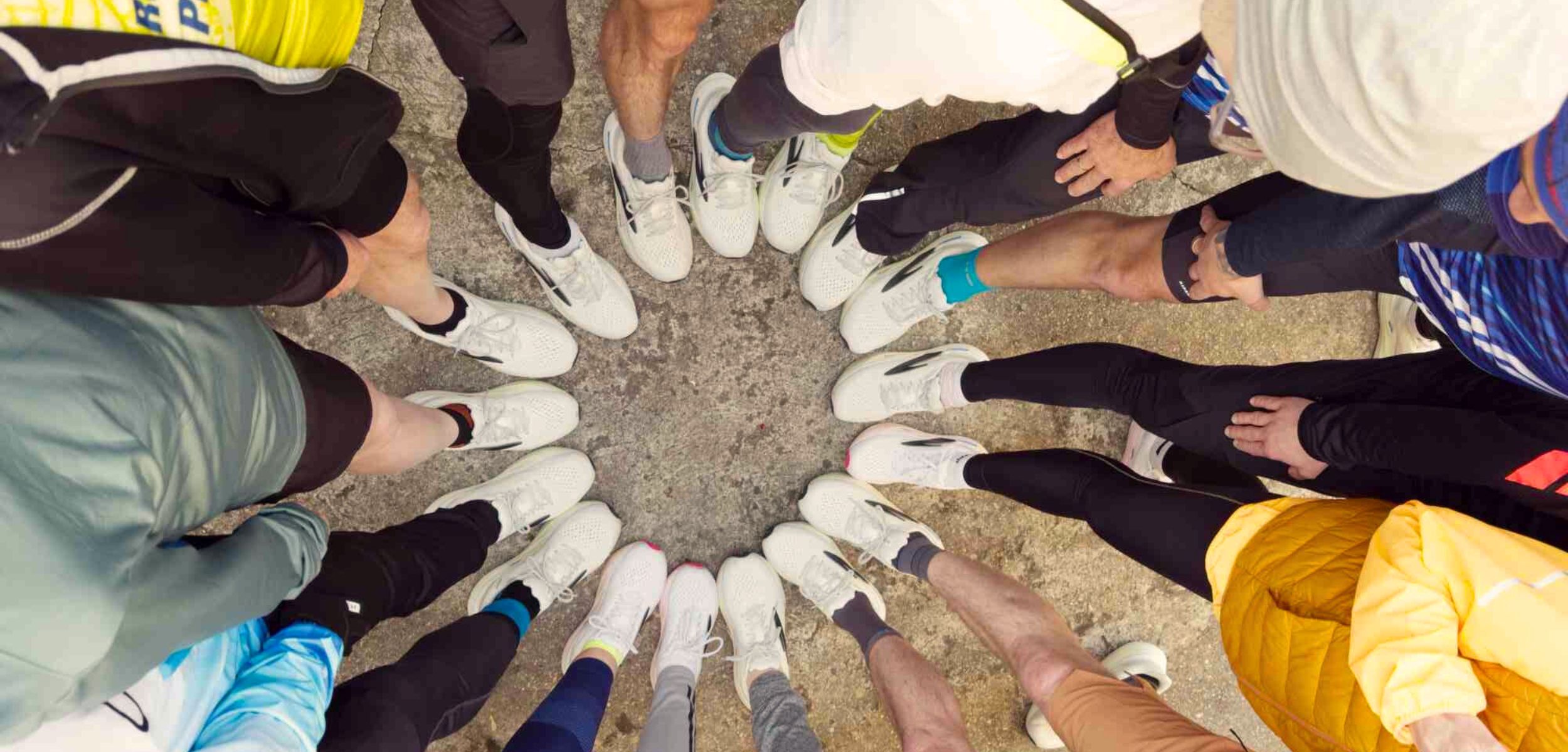 Grupa ludzi ze stopami ustawionymi w okrąg. Na stopach buty Brooks Glycerin Max